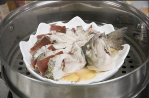 將鱸魚成花狀擺好，將火腿切片放入各縫隙中，放入鍋中隔水蒸12分鐘拿出，撒上蔥花即可。