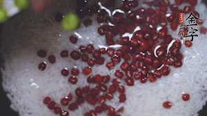 將炒好的食材和大米、紅豆一起放進(jìn)電飯鍋煮。