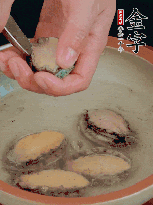 鮑魚加鹽、清水浸泡，用勺子挖出鮑魚肉。