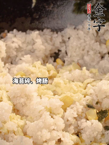 剩米飯下鍋炒散，依次下玉米粒、雞蛋、烤腸、海苔碎翻炒均勻。