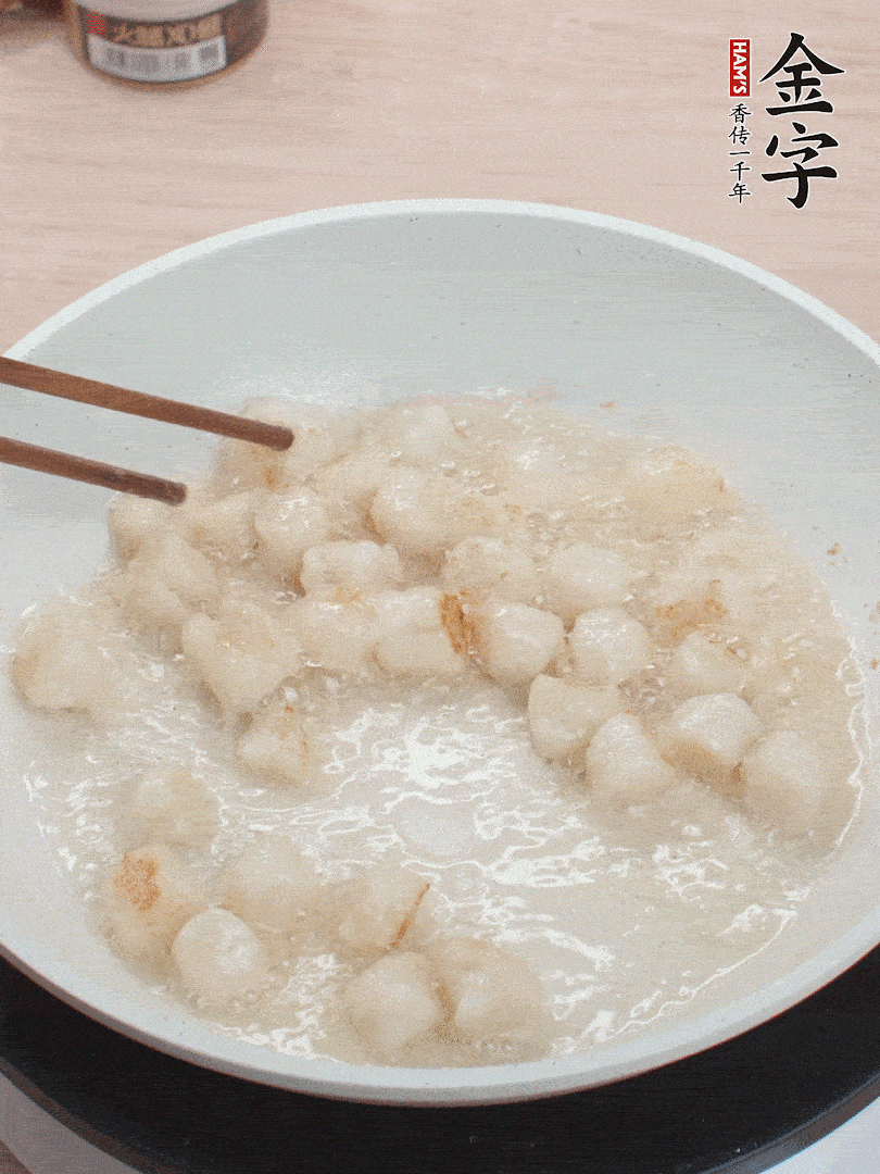 油溫4成熱，鮮貝蘸干淀粉下鍋煎，一面微黃后翻面。