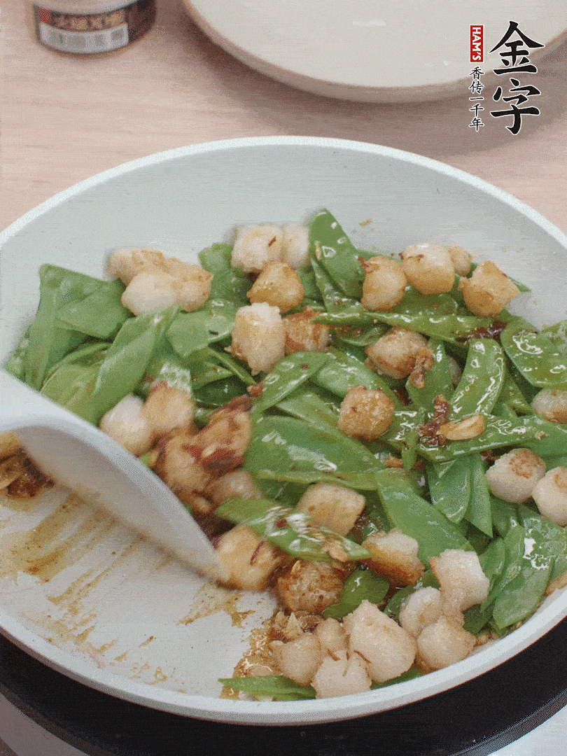 下甜豆莢、鮮貝輕輕翻炒均勻。