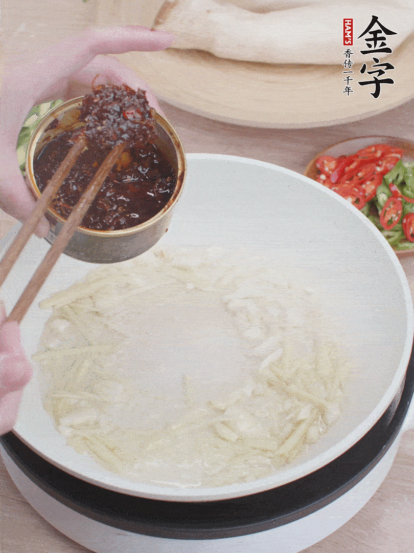 起鍋熱油，姜蒜、金字火腿干貝醬煸香。