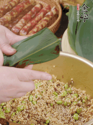 粽葉往下折，完全蓋住，兩側(cè)捏緊。