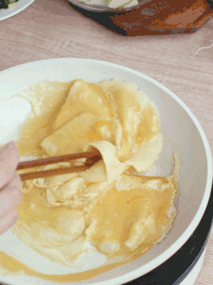 油6成熱時，下雞蛋液，邊緣凝固時翻拌成塊狀。