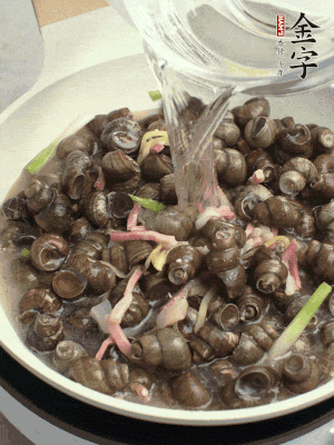 倒處理干凈的螺螄翻炒，加3勺料酒。加清水蓋過螺螄，中火蓋蓋煮5分鐘。