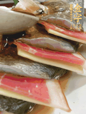 魚肚中塞蔥結(jié)、火腿片，魚身上碼放姜片、火腿片，倒入混合的料汁。