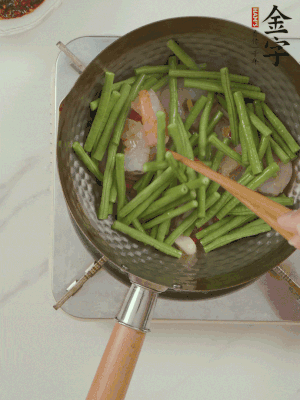 下掰好的缸豆段翻炒，略燜煮。
