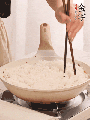 把瀝干水分的米飯均勻鋪在上面，筷子戳幾個洞，以便透氣，轉(zhuǎn)小火蓋上蓋子燜至水分收干，大概10分鐘。